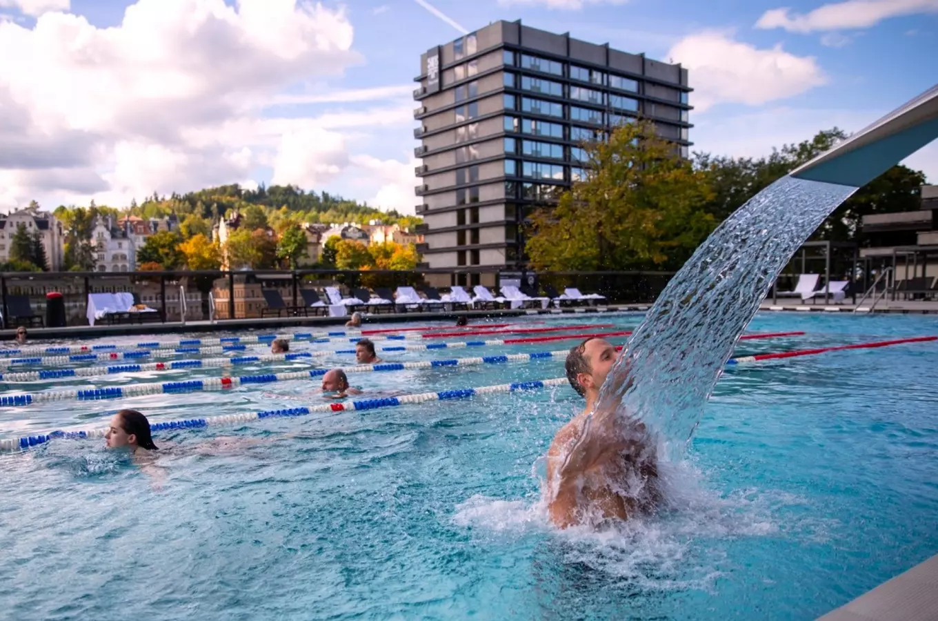 Outdoor swimming pool with waterfall feature