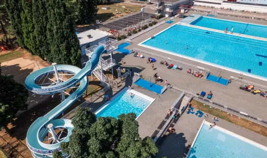 Vzdušný pohled na bazény a vodní skluzavky v koupališti.