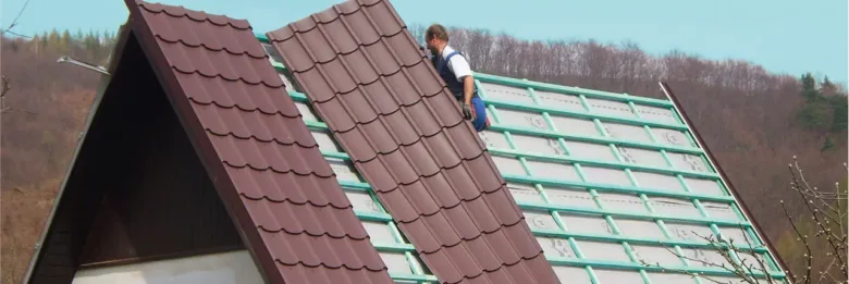 Montáž střechy s instalací tašek na sklon.