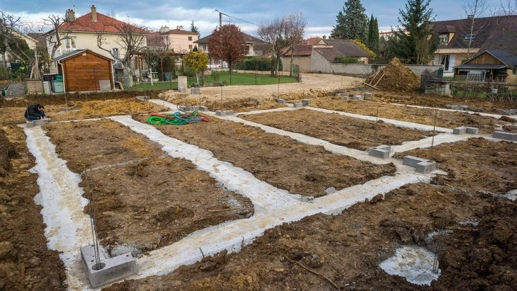 Staveniště s vybudovanými betonovymi základy pro novou stavbu.