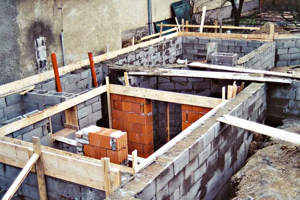 Základy budovy z bloků s dřevěným opatřením v jámě.