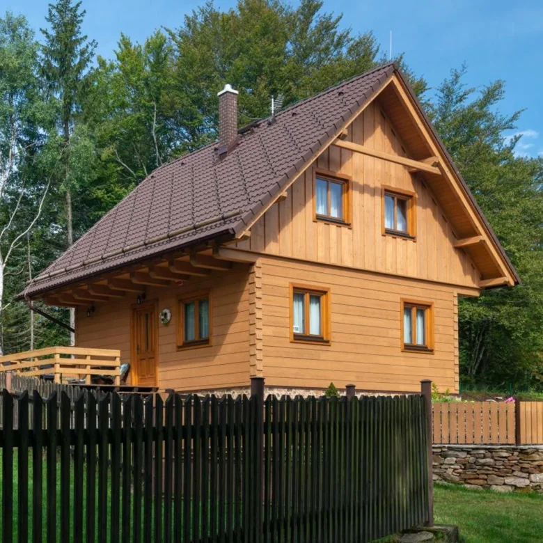 Dřevěný dům s plotem a okolním zeleň