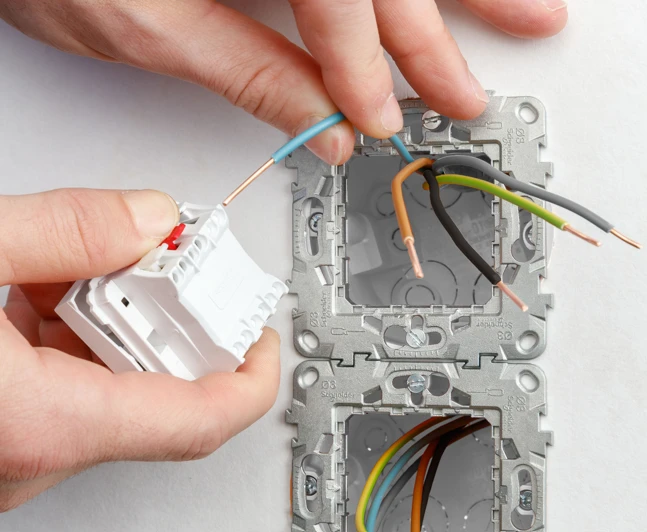 Ruční instalace vypínače s připojením vodičů do zásuvky.