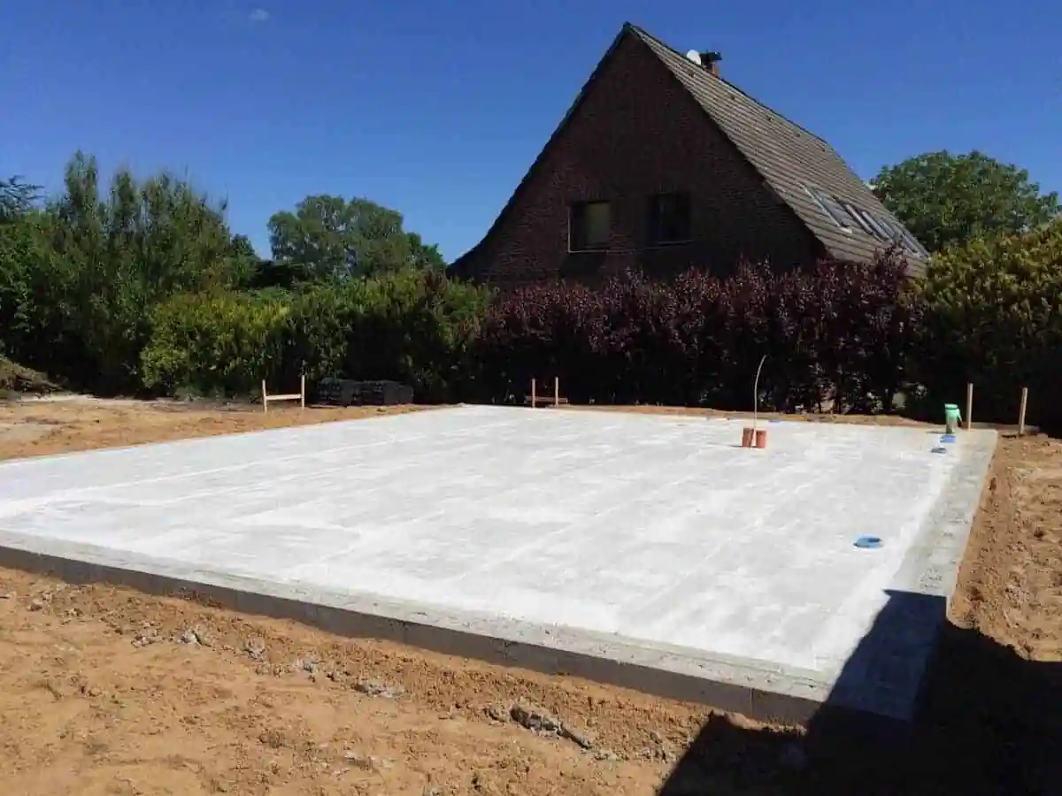 Čerstvě nalitá betonová základní deska připravená na hydroizolaci.