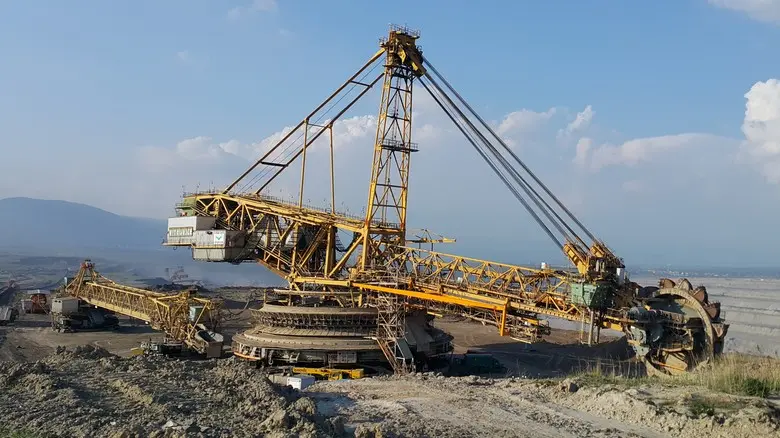Velký žlutý výkopový stroj na dole uhlí pro energetiku.