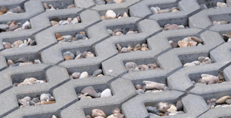 Betonové zatravňovací kostky s kamínky na chodníku.