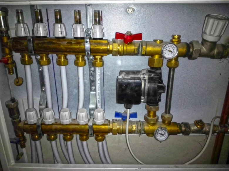 Rozvodnice pro podlahové topení s hadicemi v elektrickém skřítku.