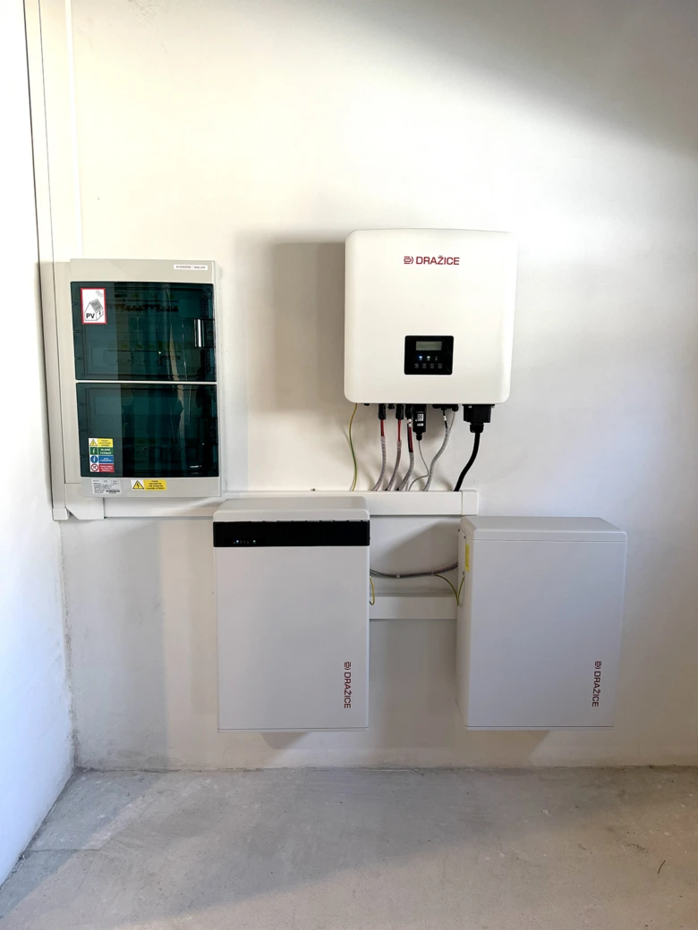 Instalace solárního měniče s bateriemi na zdi v interiéru.