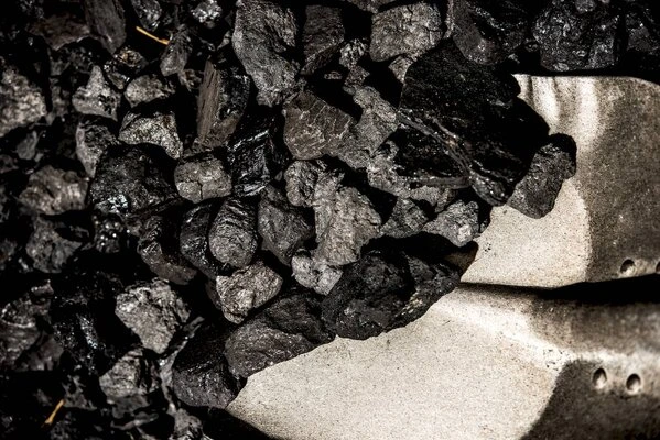 Černé kusy uhlí v kovové lopatě pro energetiku.