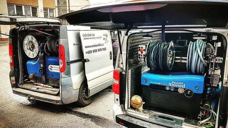 Dva nákladní vozy s vysavači pro údržbu bytů