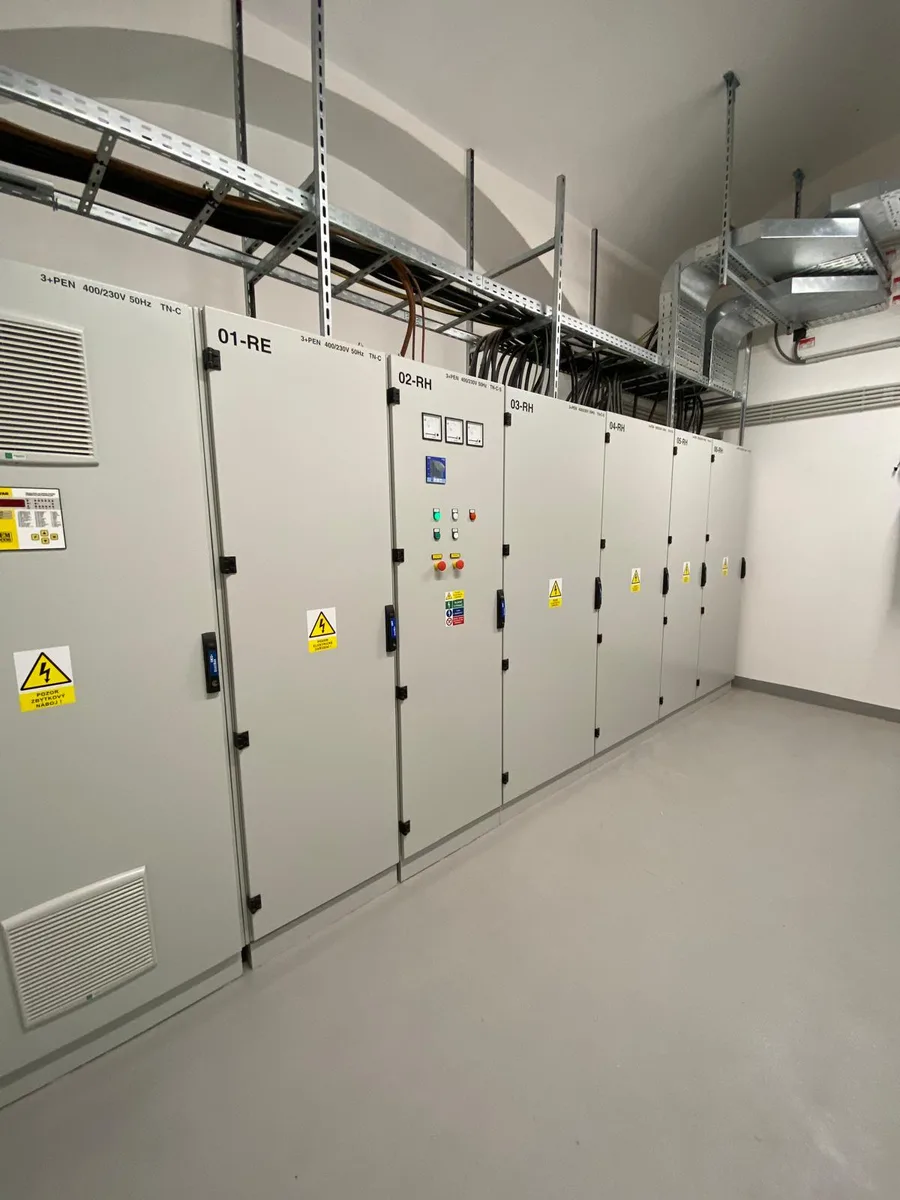 Řada průmyslových elektrických rozvaděčů v čistém technickém prostoru.