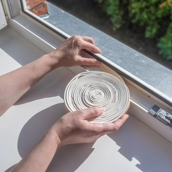 Ruční instalace těsnicí pásky do rámu okna.