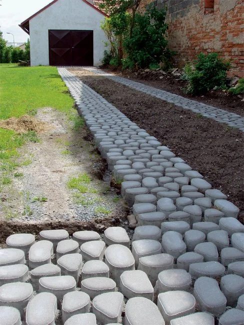 Betonové zatravňovací kostky položené v zahradní cestě vedle půdy.