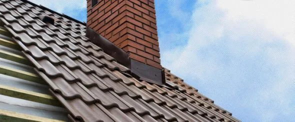Kamínová komína s kovovým oplechováním na střeše.
