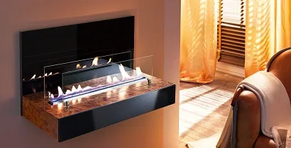 Moderní krb na biolíh s plameny v interiéru vedle pohovky.