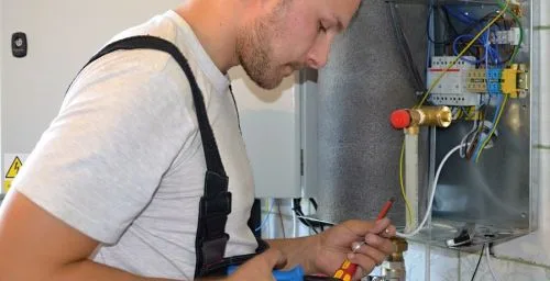 Technik montuje tepelné čerpadlo do starého domu.
