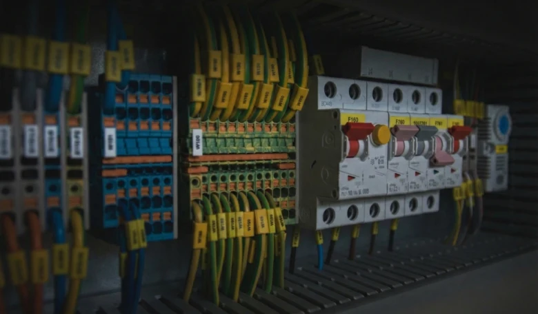 Vnitřní sestava elektrického rozvaděče s pojistkami a označenými vodiči.
