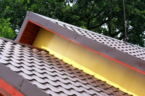 Detailní pohled na štítové lemování střechy s taškami.