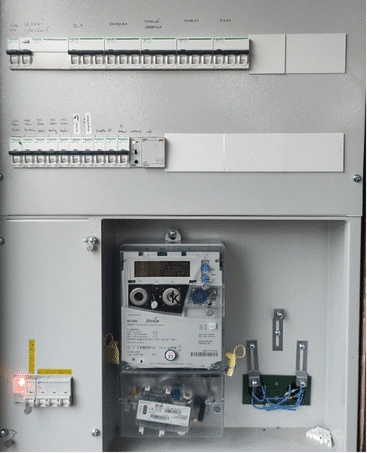 Otevřená elektrická rozvaděč s jističi a měřidlem energie.
