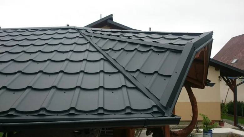 Detailní pohled na tmavě šedou plechovou střechu s viditelnými hřebíky.