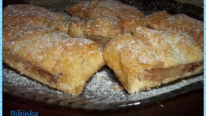 Upečené kousky jablkového štrúdlu posypané cukrem.