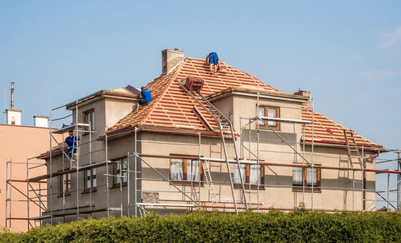 Práce na rekonstrukci střechy domu s lešení.