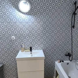 Moderní koupelna po rekonstrukci s dlažbou na stěnách.