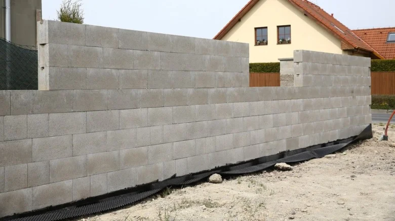 Stavební práce s betonovými bloky pro ztracené bednění.