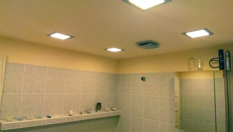 Bodová světla v koupelně s vývěvou na stropě.