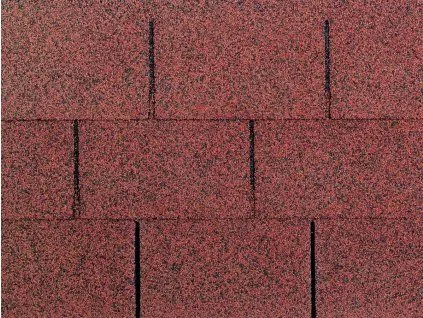 Detail červené asfaltové střešní krytiny s granulovanou povrchovou úpravou.