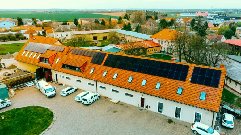 Dům s fotovoltaickými panely na střeše v českém venkovském prostředí.