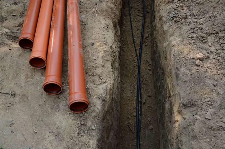Oranžové vodovodní trubice uložené v zemi pro ochranu před mrazem.