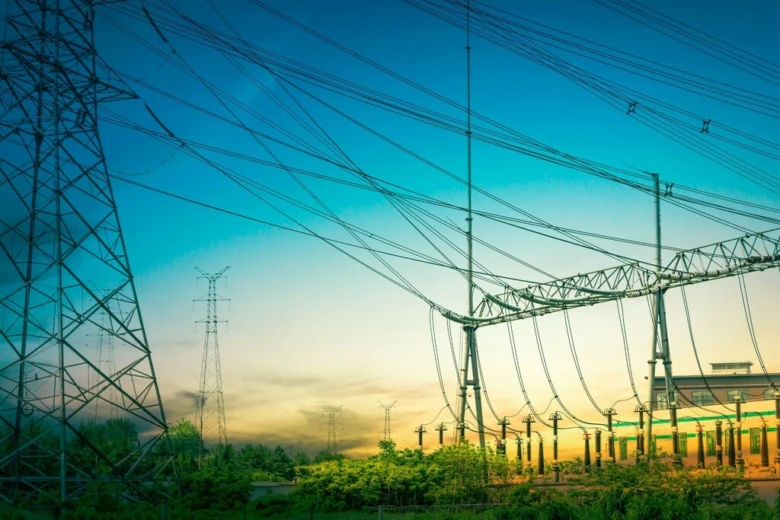 Vysokonapěťové vedení a elektrická infrastruktura v západu slunce.