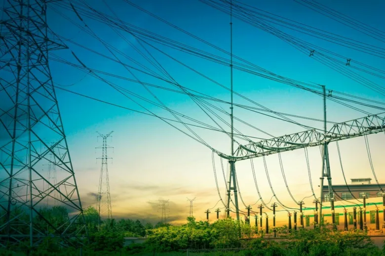 Vysokonapěťové vedení s elektrickými věžemi při západu slunce.