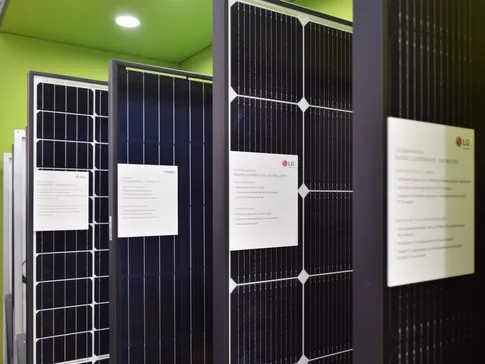 Výstava fotovoltaických panelů s informačními štítky v interiéru.