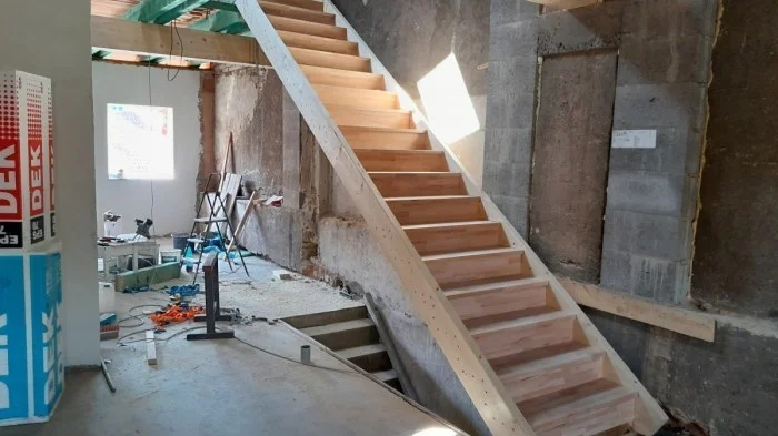 Dřevěné schody se staví ručně v interiéru během rekonstrukce.