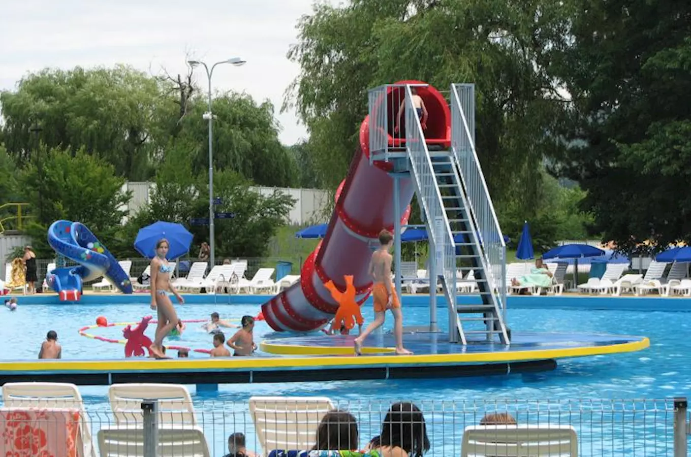 Koupaliště s vodním skluzavkou a bazénem pro plavání.
