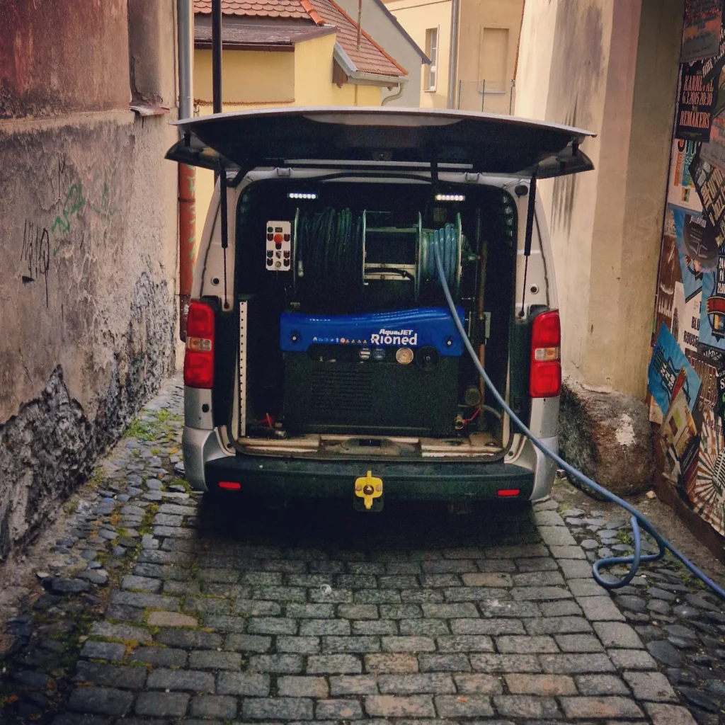 Stoupačka pro čištění kanalizace zaparkovaná v uličce.