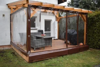 Pergola s plachtou pro venkovní sedací soupravu.