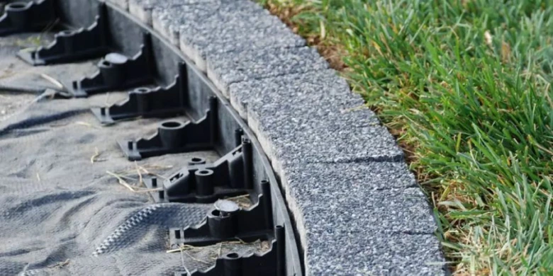 Instalace obloukové opěrné zdi na svahu s odvodňovacím systémem.
