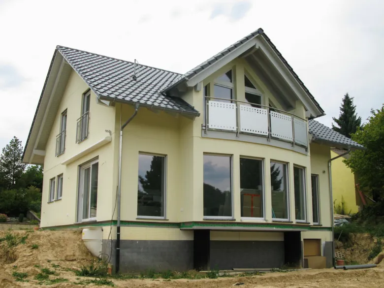 Nově natřená fasáda domu světle žlutou barvou.