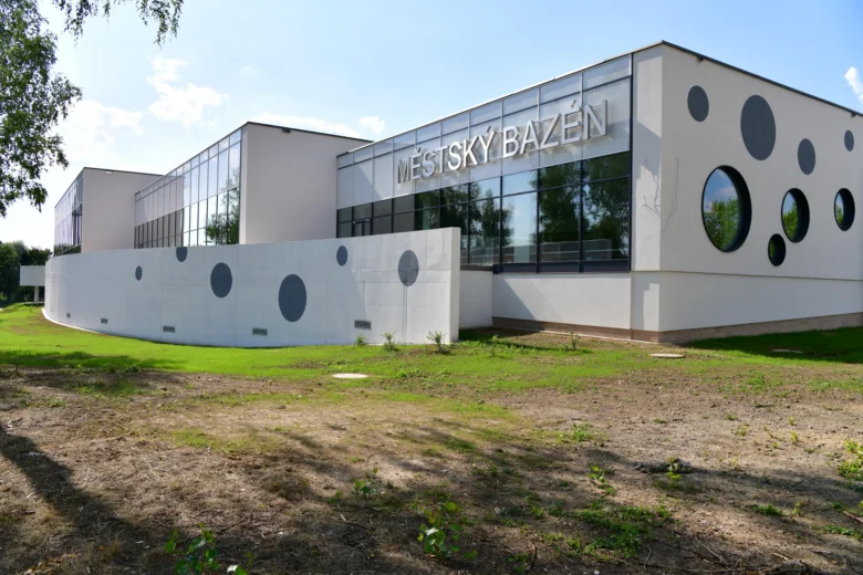 Moderní krytý městský bazén v Karviné s kruhovými okny.