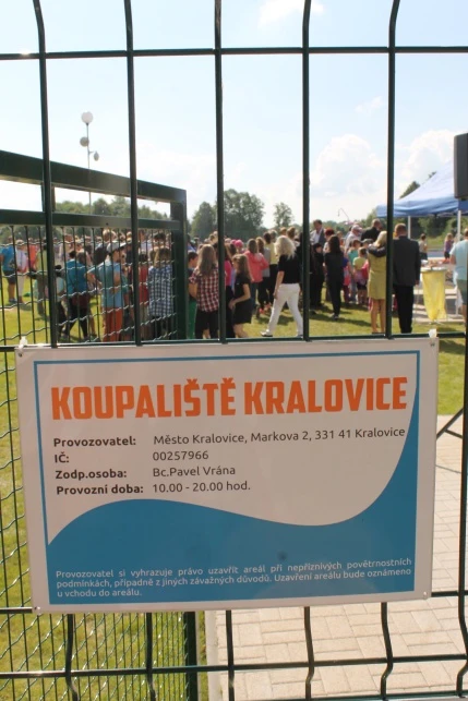 Informační tabule koupaliště v Královicích na plotě.