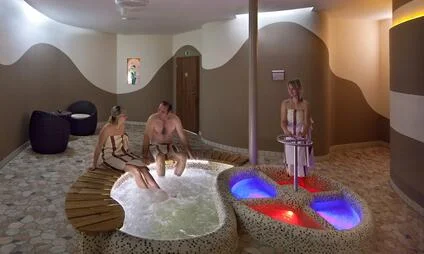Vnitřní bazén s hydromasáží a relaxační zónou v sauně.