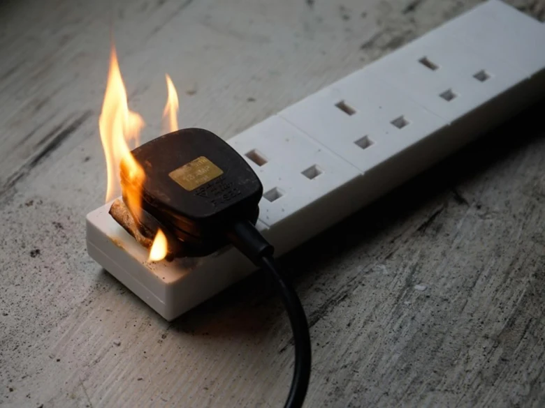 Zapalující se elektrická zásuvka ukazuje nebezpečí poruch.