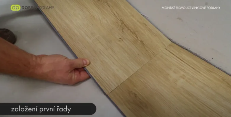 Ruční pokládka první řady vinylové podlahy na podklad.