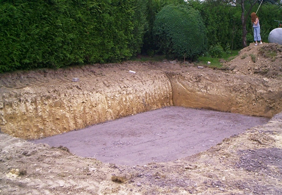 Vykopaná jáma pro betonový bazén s připraveným dnem.