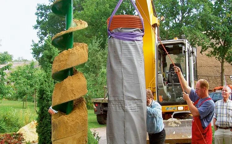 Bager zvedá pytel s pískem při práci na technické šachtě.