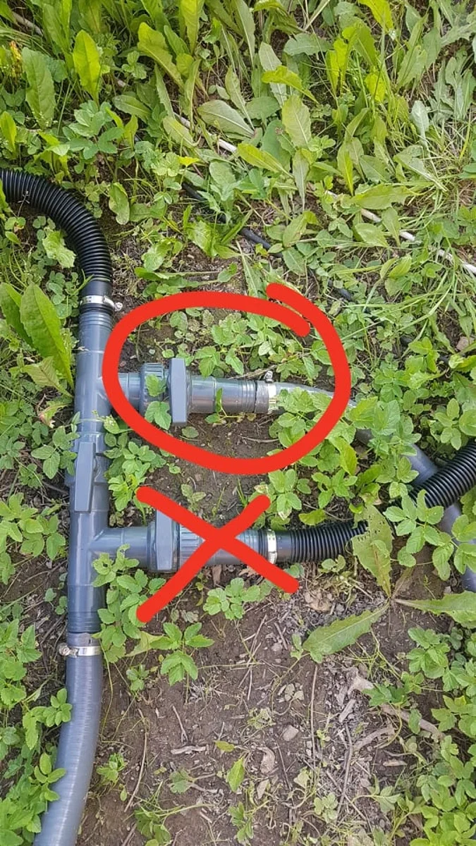 Fotografie šedých potrubí pro solární ohřev bazénu na trávníku.