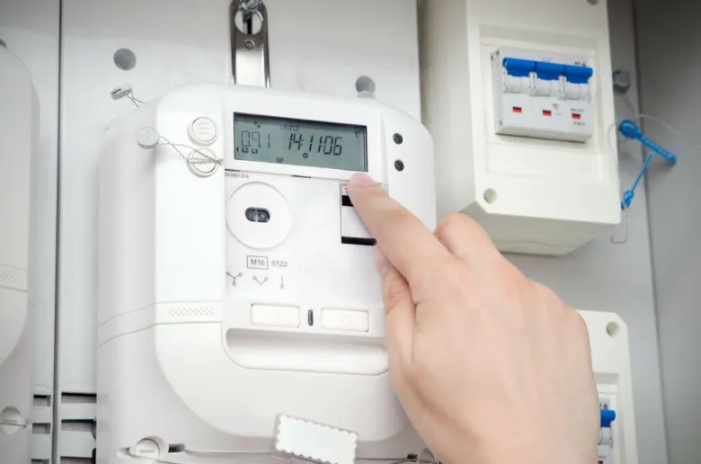 Ruka otevírá displej elektroměru pro odečtení stavu.